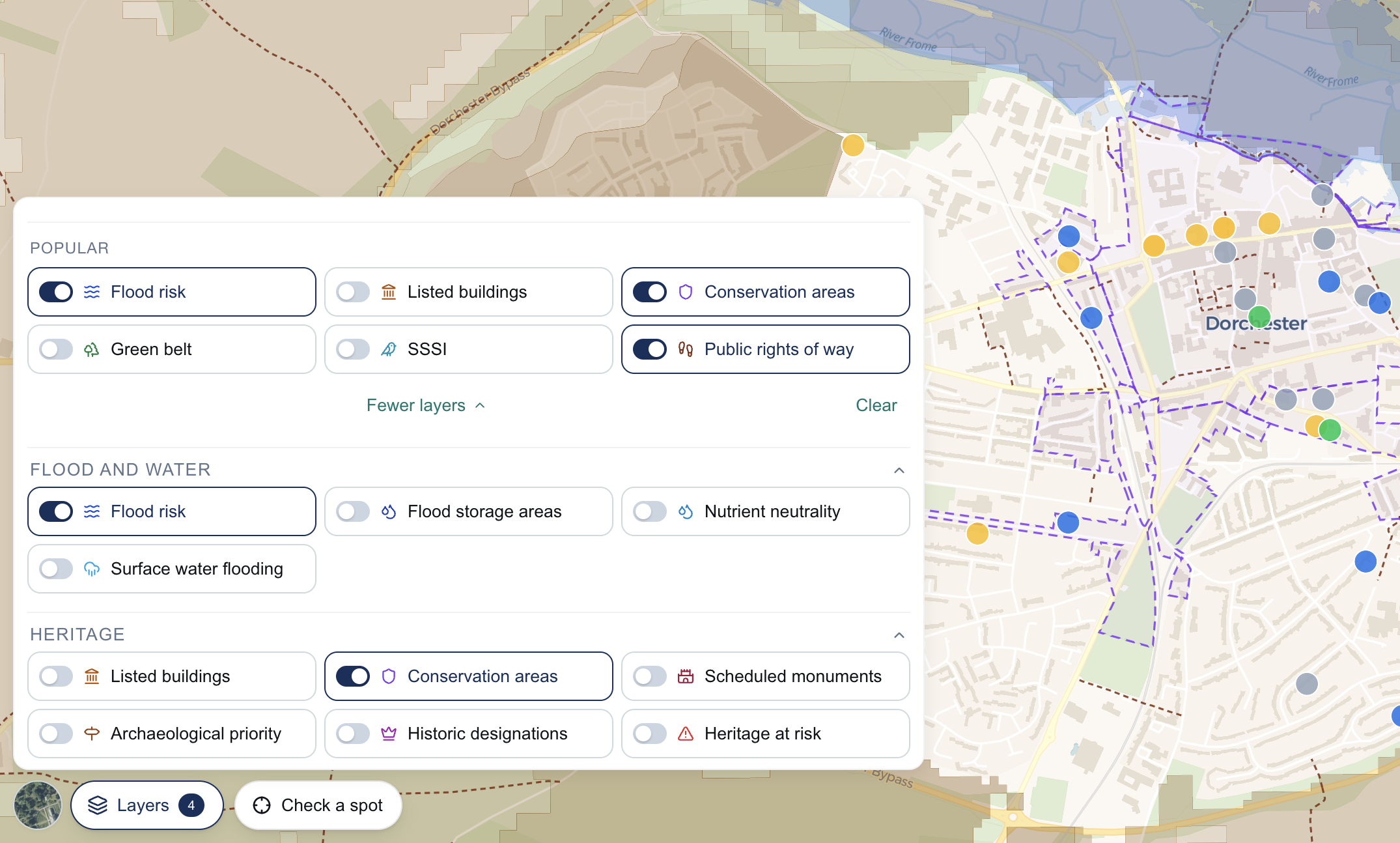 A map with flood risk, listed buildings, conservation areas and other constraint layers drawn on it, and the Layers panel open beside them